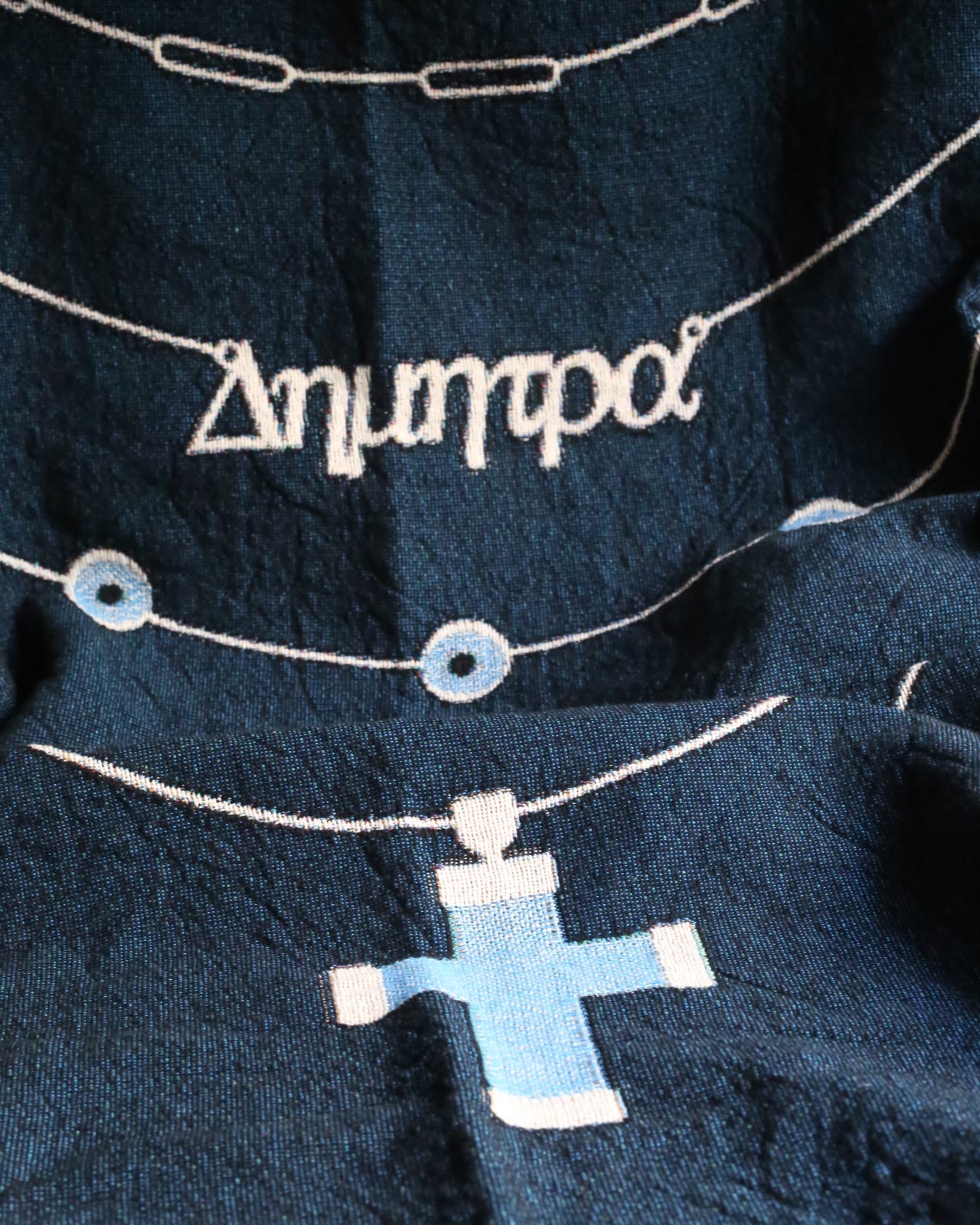 Navy blue fabric with embroidered text and shapes